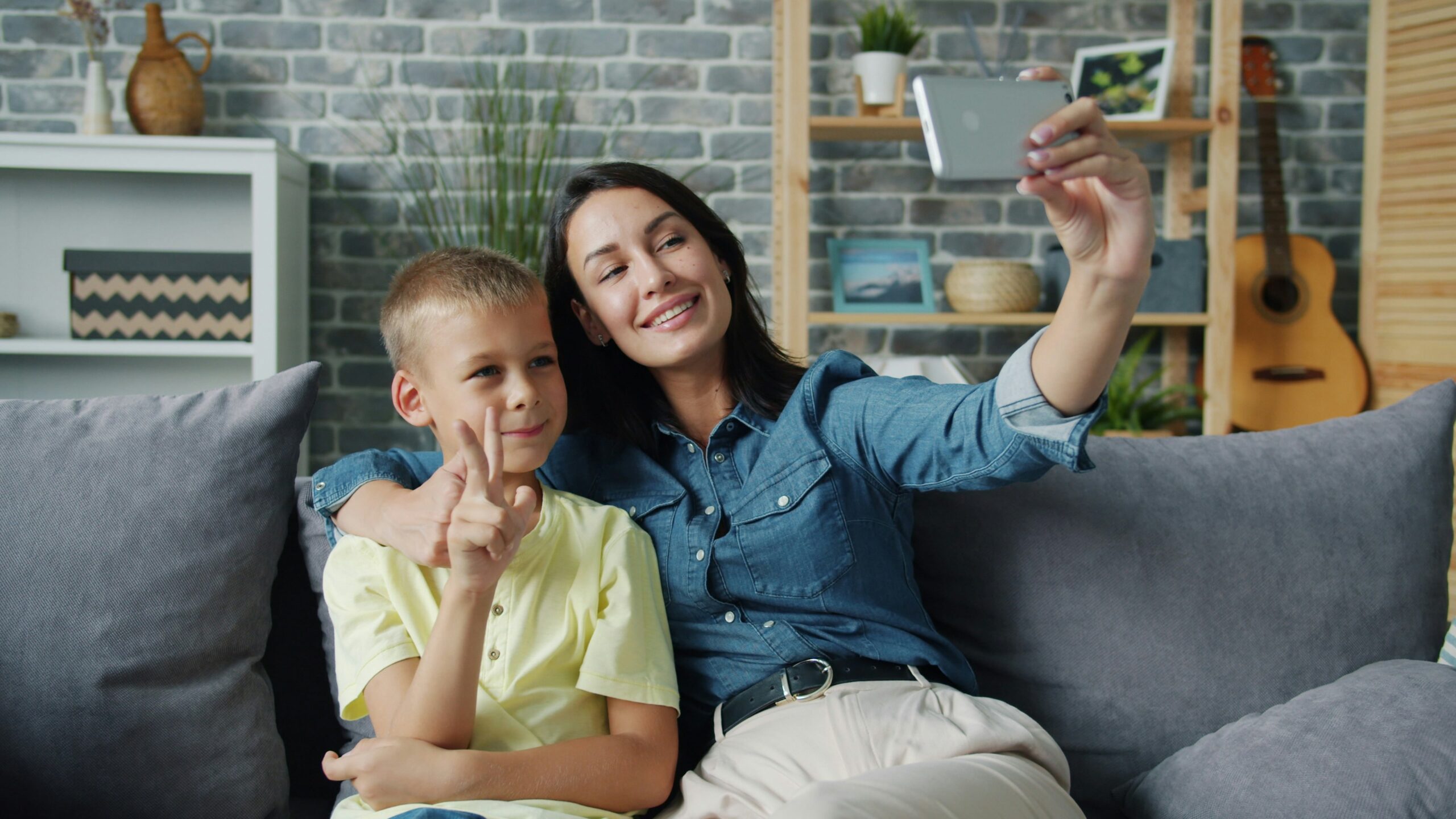 Ouder gebruikt smartphone voor gezinsplanning terwijl kinderen thuis spelen