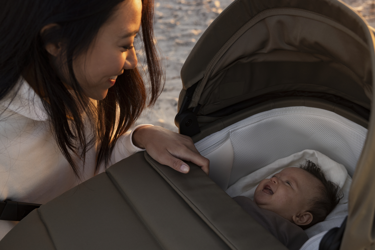 Ouder met de baby in Thule Charm 2 in 1 kinderwagen met reiswieg